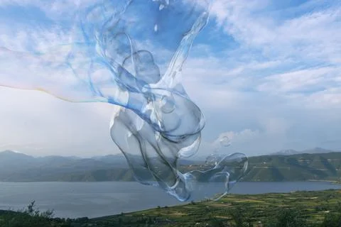 Giant colourful soap bubble twisting in front of lake and mountains Fotos Stock
