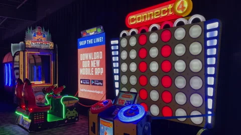 Giant Connect 4 and Space Invaders arcade game machines illuminated in a Dave-21 Stock Footage 339490921