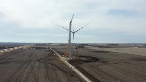 Giant crane with lifted windmill blade close to the rotor of the windmill Stock Footage 151072409