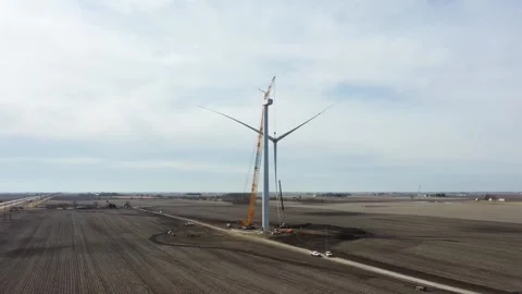 Giant crane with lifted windmill blade close to the rotor of the windmill Stock Footage 151073852