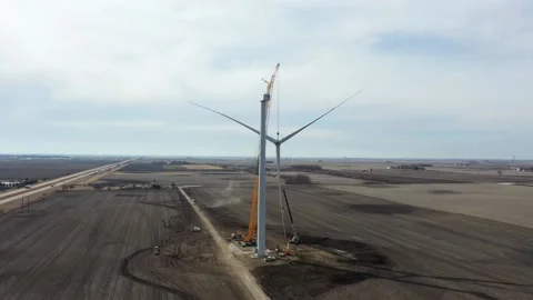Giant crane with lifted windmill blade close to the rotor of the windmill Stock Footage 151073922