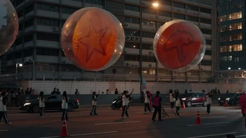 Giant dalgona candy balloons from 'Squid Game' float in a nighttime parade in Stock Footage 312319913