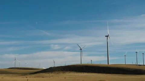 Giant distant windmills in wind farm and moon 60fps 2x slow Video stock 237417619