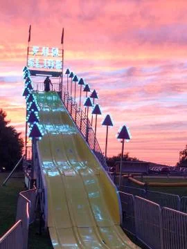 Giant fun slide at fairgrounds at sunset Stock Photos