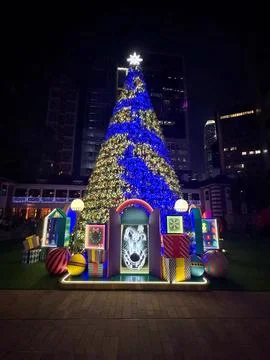 Giant illuminated Christmas tree and festive decorations light up the night.. Stock Photos