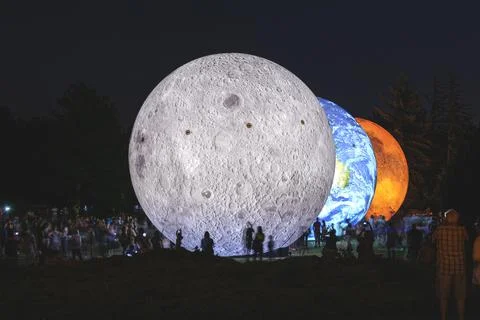 Giant inflatable model of the planets Mars, Earth and Moon at night with Stock Photos