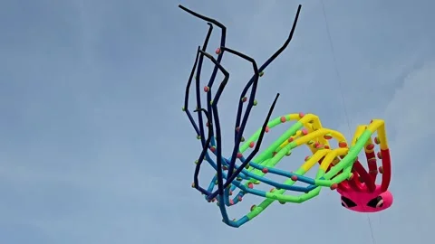 A giant inflatable octopus kite gracefully soars through the clear blue sky. Stock Footage 304401668