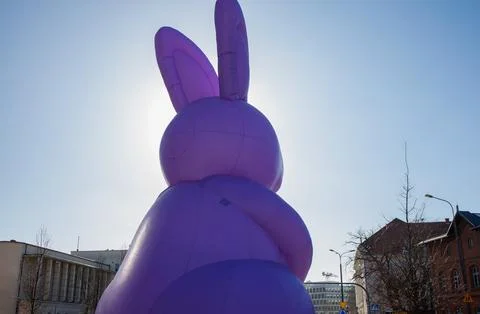 Giant inflatable purple Easter bunny statue standing in city center. Tradit.. Foto stock