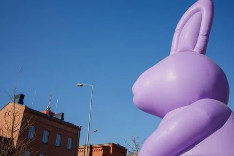 Giant inflatable purple Easter bunny statue standing in city center. Tradit.. Foto stock