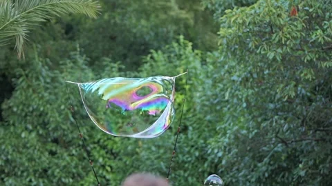Giant iridescent soap bubble floating and popping Stock Footage 340280422