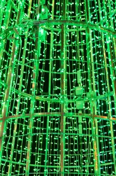 A giant light tunnel structure glows green against the night sky. Stock Photos
