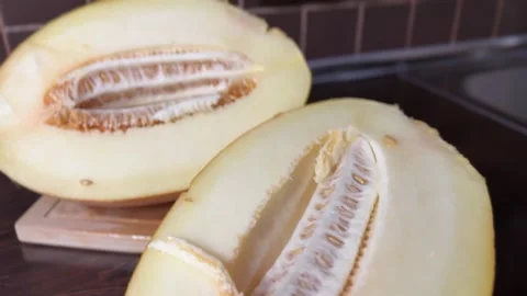 Giant Melon Cut in Half on Kitchen Cutting Board Stock-Footage 315991735