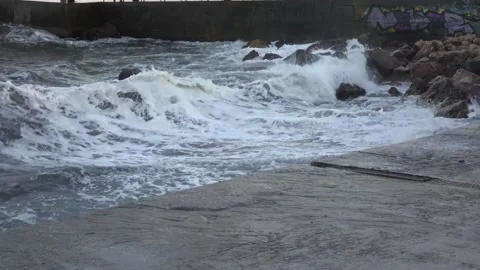 Giant ocean waves fall on the shore. Storm in the town Stock Footage 130876031