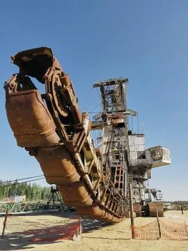 Giant old absetzer rusts in a sand quarry. Huge mining excavator. Stock Photos