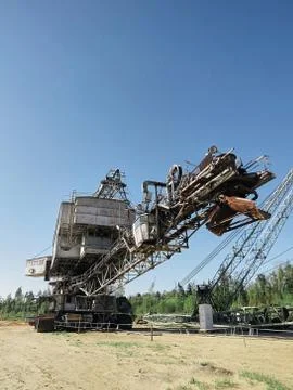 Giant old absetzer rusts in a sand quarry. Huge mining excavator. Stock Photos