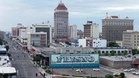 Giant postage stamp mural spelling Fresno covers blue building wall, empty Stock Footage 339994701