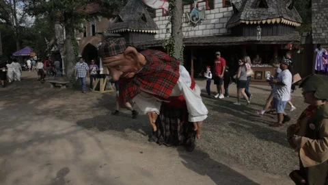 Giant Puppet Performer Bending to Touch Nose to Ground at Renaissance Faire Stock Footage 345275982