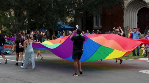 Giant Rainbow Flag Carried Down the Street at Jacksonville Pride Parade Stock Footage 346920035