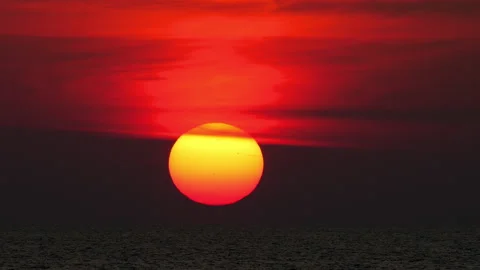 Giant red sun setting over the calm ocean horizon at dusk Stock Footage 336188470