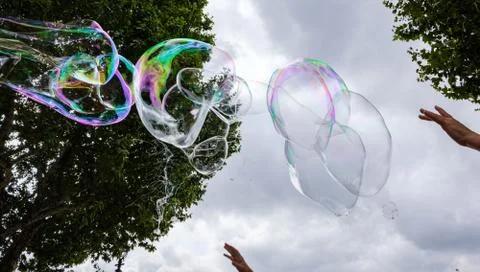 Giant soap bubbles explode at the touch of children's hands Stock Photos