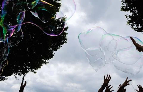 Giant soap bubbles explode at the touch of children's hands Stock Photos