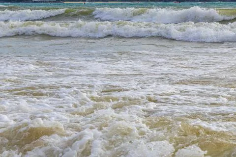 Giant turquoise ocean waves rolling beside sandy tropical paradise shorelin.. Stock-Fotos