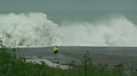 Giant Waves Crash Onto Beach Near Man Stock Footage