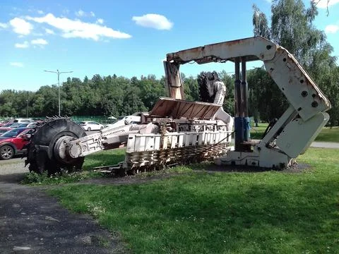 Giant white coal mining machine in Landek museum next to parking places. Stock Photos