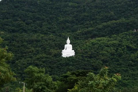 Giant white image of buddha with the green mountain background Stock Photos