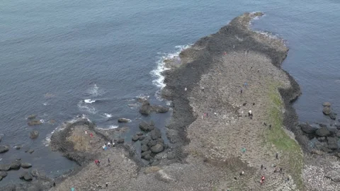Giant's causeway hexagonal basalt columns viewed from above. People explore the Stock Footage 311756824