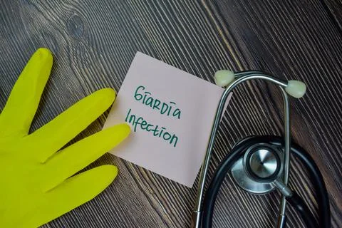 Giardia Infection write on sticky notes isolated on Wooden Table. Foto stock
