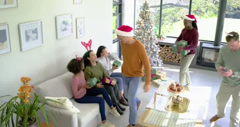 Gift arrival sparking Diverse friends exchanging gifts on sofa and snapping Stock Footage 335683039