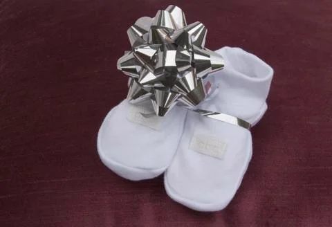 Gift of baby booties given to expectant grandparents Stock Photos
