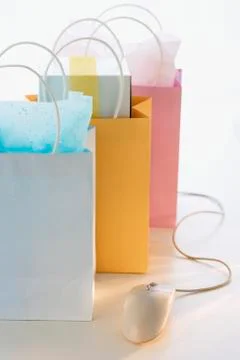 Gift bags next to computer mouse Stock-Fotos