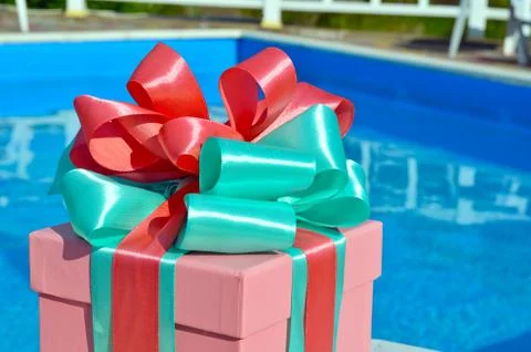Gift box against the background of the pool. Stock Photos