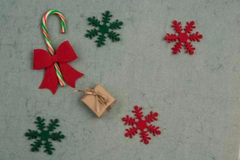 Gift box and candy cane on a green background for new year Stock Photos