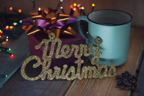 Gift box and cup of coffee, gold inscription on the table Stock Photos