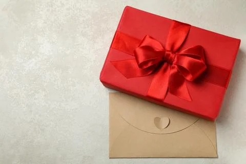 Gift box and envelope on white textured background Stock Photos