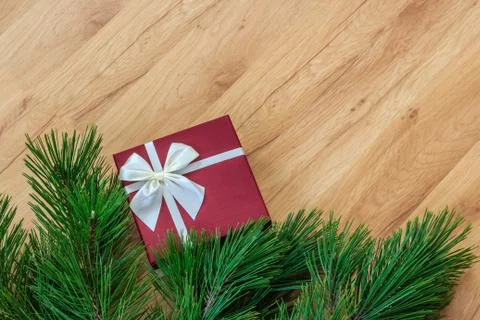 Gift box and pine branches on wooden background, bottom border, space for text	 Foto stock