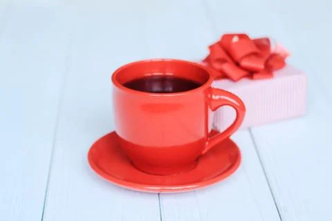 Gift box and red Cup on a light wooden background Stock Photos