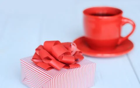 Gift box and red Cup on a light wooden background Stock Photos
