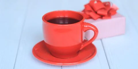 Gift box and red Cup on a light wooden background Stock Photos