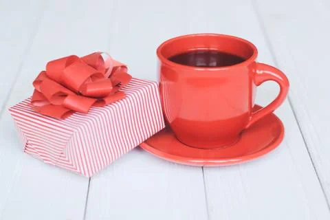 Gift box and red Cup on a light wooden background Stock Photos