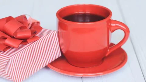 Gift box and red Cup on a light wooden background Stock Photos