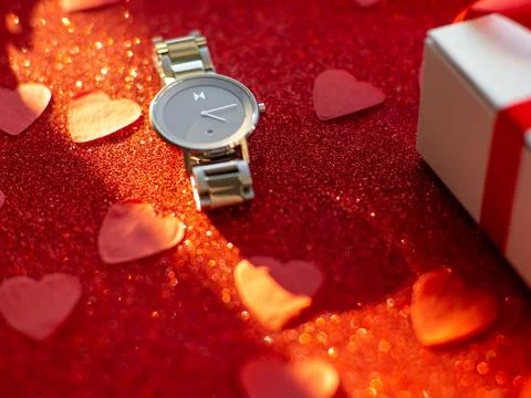 Gift box and silver watch is on red heart paper background Stock Photos