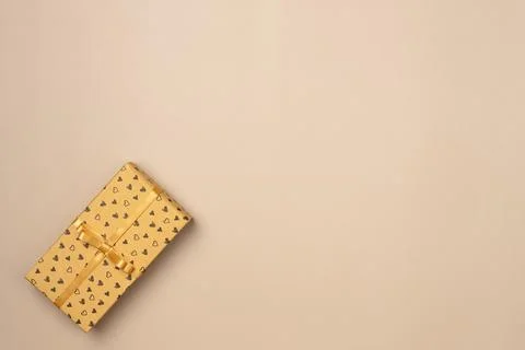 Gift box on beige background from above. Flat lay, top view. Stock Photos