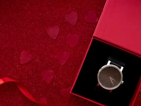 Gift box with black watch is on red heart paper background Stock Photos