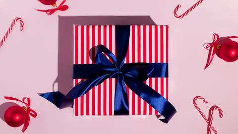 Gift box with blue ribbon on pink background. Flat lay, top view Stock Photos