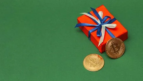 Gift box with a bow and two bitcoins. 스톡 사진