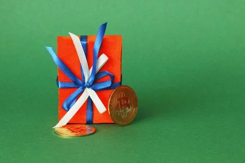 Gift box with a bow and two bitcoins. Stock Photos